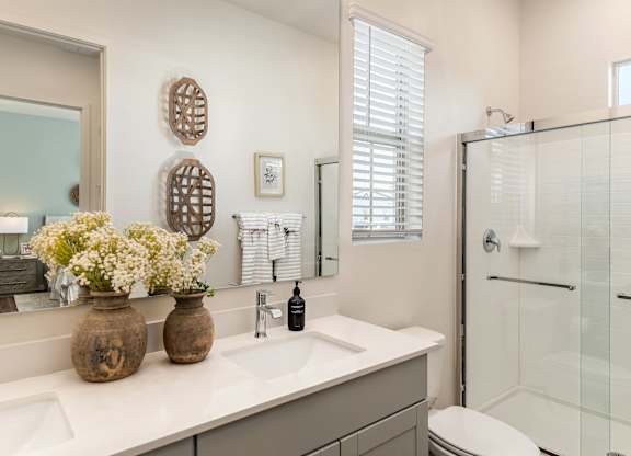 Bathrooms with dual sinks, wood plank floors, walk-in showers  at Pillar at Fountain Hills