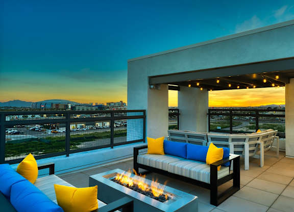 Rooftop patio with tables and chairs and firepit at dusk at Cuvee, Arizona