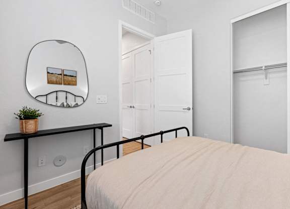 a bedroom with a bed and a mirror and closets at Village of Chandler Apartments, Chandler, 85249