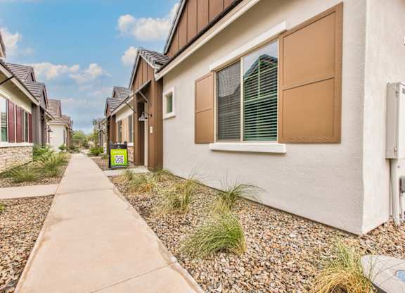 a row of houses with a sidewalk in front of them at Village of Chandler Apartments, Chandler, AZ