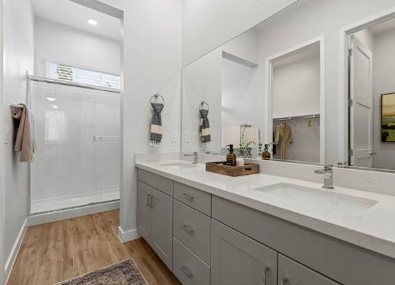 a bathroom with a sink and a shower and a mirror at Village of Chandler Apartments, Chandler, Arizona