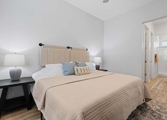 a bedroom with a large bed and a door to a bathroom at Village of Chandler Apartments, Chandler, 85249