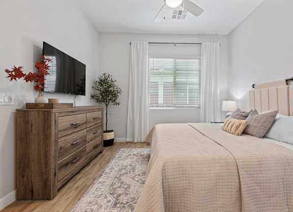 a bedroom with a bed and a tv at Village of Chandler Apartments, Chandler, AZ, 85249