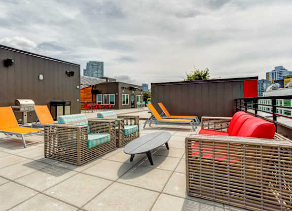 A patio with a table and chairs on the roof top.