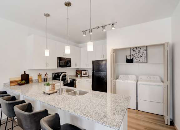 A kitchen with a white countertop and black appliances.