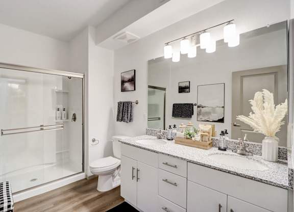 A bathroom with a white toilet, a sink, and a mirror.