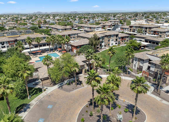 View of a residential area with a swimming pool and palm trees.