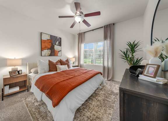 A bedroom with a large bed and a ceiling fan.