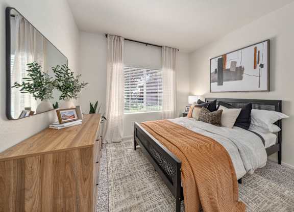 A bedroom with a bed, nightstand, and a mirror on the wall.