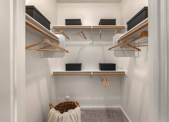A small closet with a white background and a brown basket.