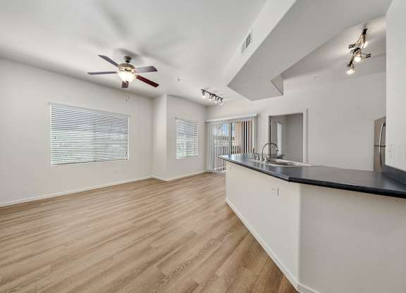 A room with a ceiling fan and wooden flooring.