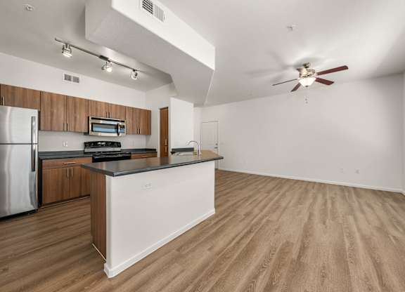 A kitchen with a refrigerator, microwave, and oven.