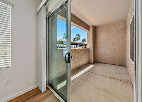 A room with a sliding glass door leading to a balcony.