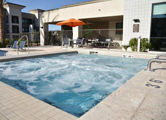 A pool with a hot tub in the middle of it.