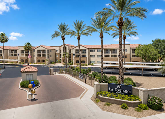 A sunny day at La Fontaine apartment complex with palm trees and a clear blue sky.