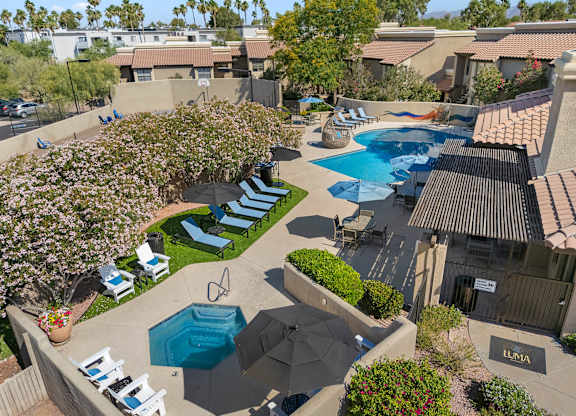 A pool surrounded by chairs and umbrellas.