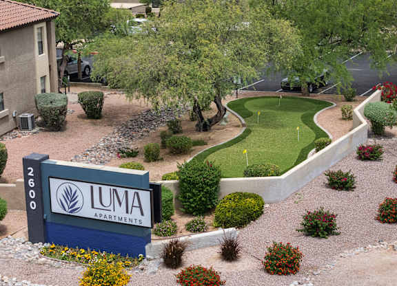 A sign for Luma Apartments is in front of a landscaped area.