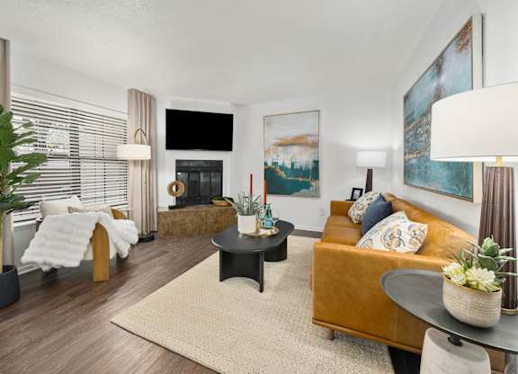 A living room with a fireplace, a couch, and a painting on the wall.