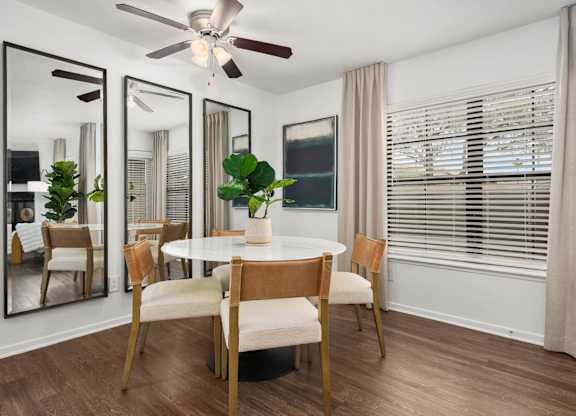 A dining room with a round table and chairs.