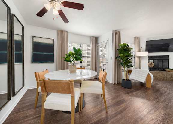 A modern dining room with a round table and chairs.