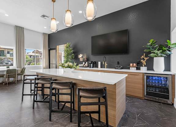 A modern kitchen with a bar area and a television mounted on the wall.