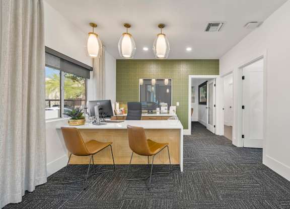 A modern office with a green accent wall and two chairs.
