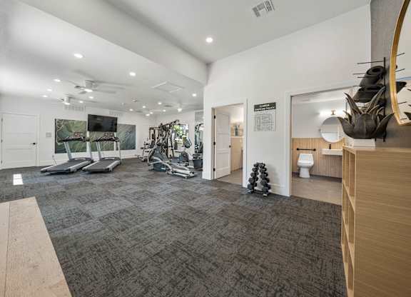 A gym with treadmills, weights, and exercise equipment.