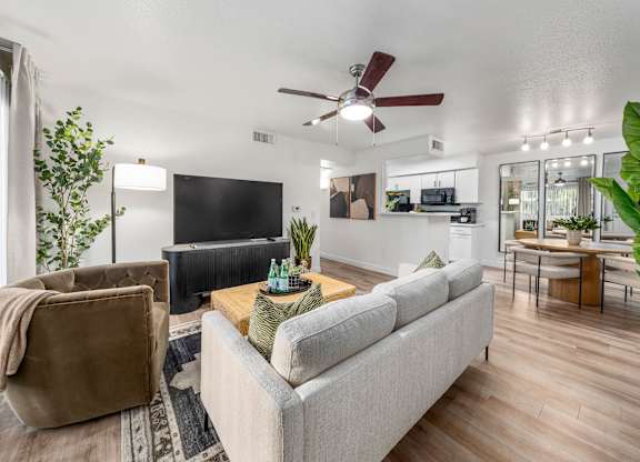 living room with a grey couch, a brown chair, and a wooden floor.