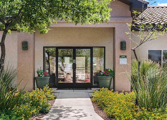 A building with a glass door entrance surrounded by plants.