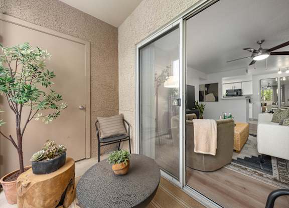 A living room with a glass door leading to a kitchen.