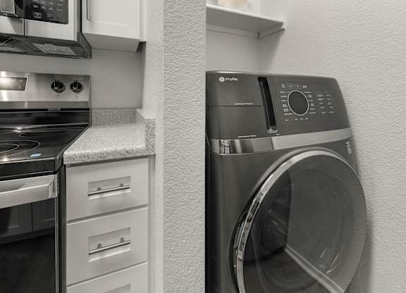 A photo of a washing machine in a kitchen.