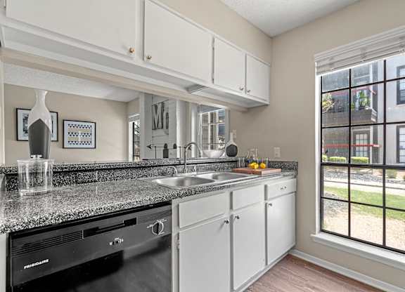 A kitchen with black appliances and granite countertops.