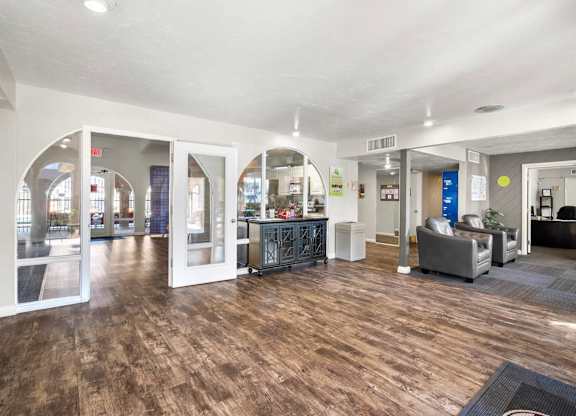 A spacious office lobby with a wooden floor and white walls.