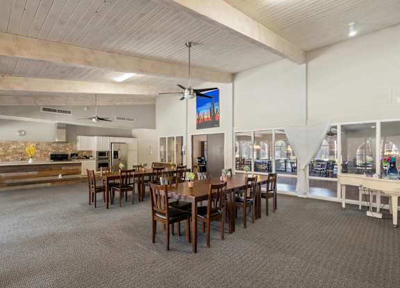 A large dining room with a long table and chairs.