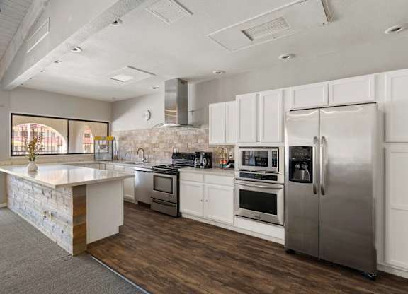 A modern kitchen with stainless steel appliances and white cabinetry.