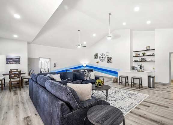 A living room with a grey couch and a blue accent wall.