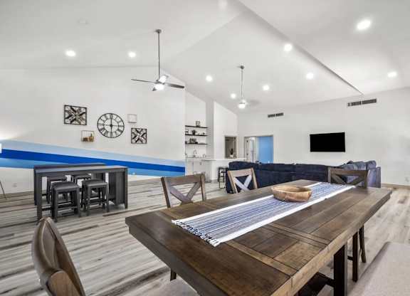 A modern dining room with a wooden table and chairs.