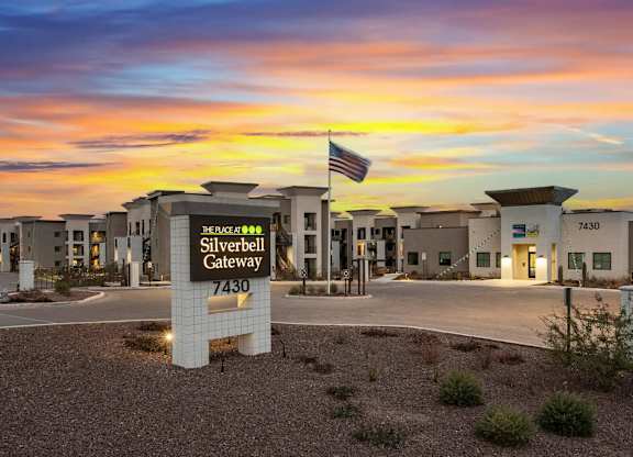 The image shows the Silverbell Gateway with a sunset in the background.