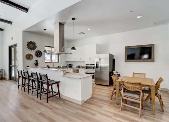 A modern kitchen with wooden floors and a white island.