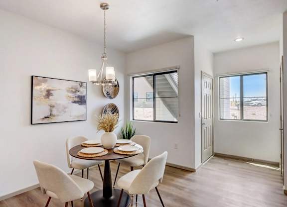 A dining room with a table set for four.