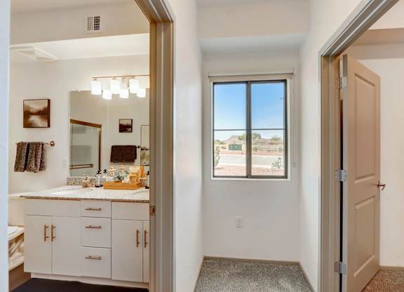 A bathroom with a large mirror and a window overlooking a parking lot.