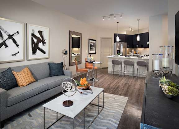 A modern living room with a grey couch and a coffee table in the center.
