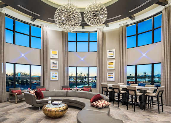 A modern living room with a large chandelier and a view of the city.