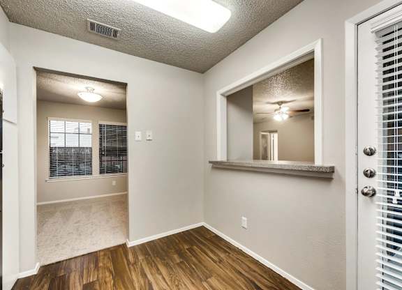 A room with a wooden floor and a door with a window.