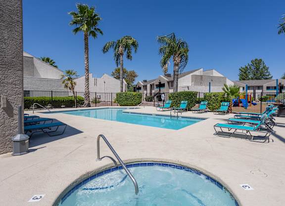 A pool with a slide and sun loungers.