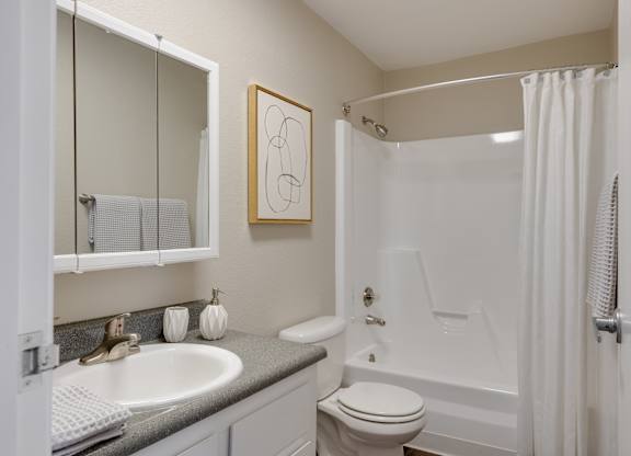 A bathroom with a toilet, sink, and bathtub.