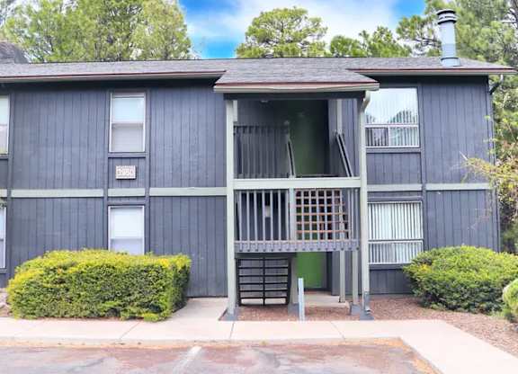 A two-story building with a balcony and a green door.