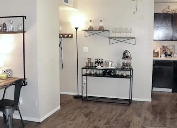 A room with a bar area and a dining table.