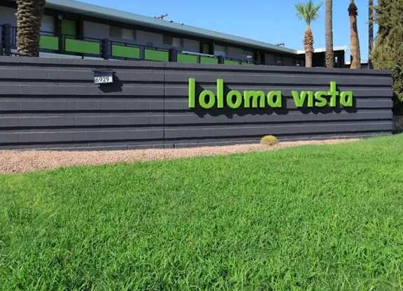 A building with a sign that says "loloma vista" in front of it.
