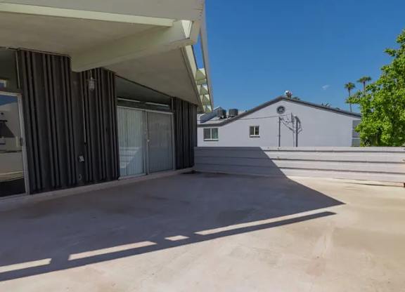 A modern house with a flat roof and a covered patio area.